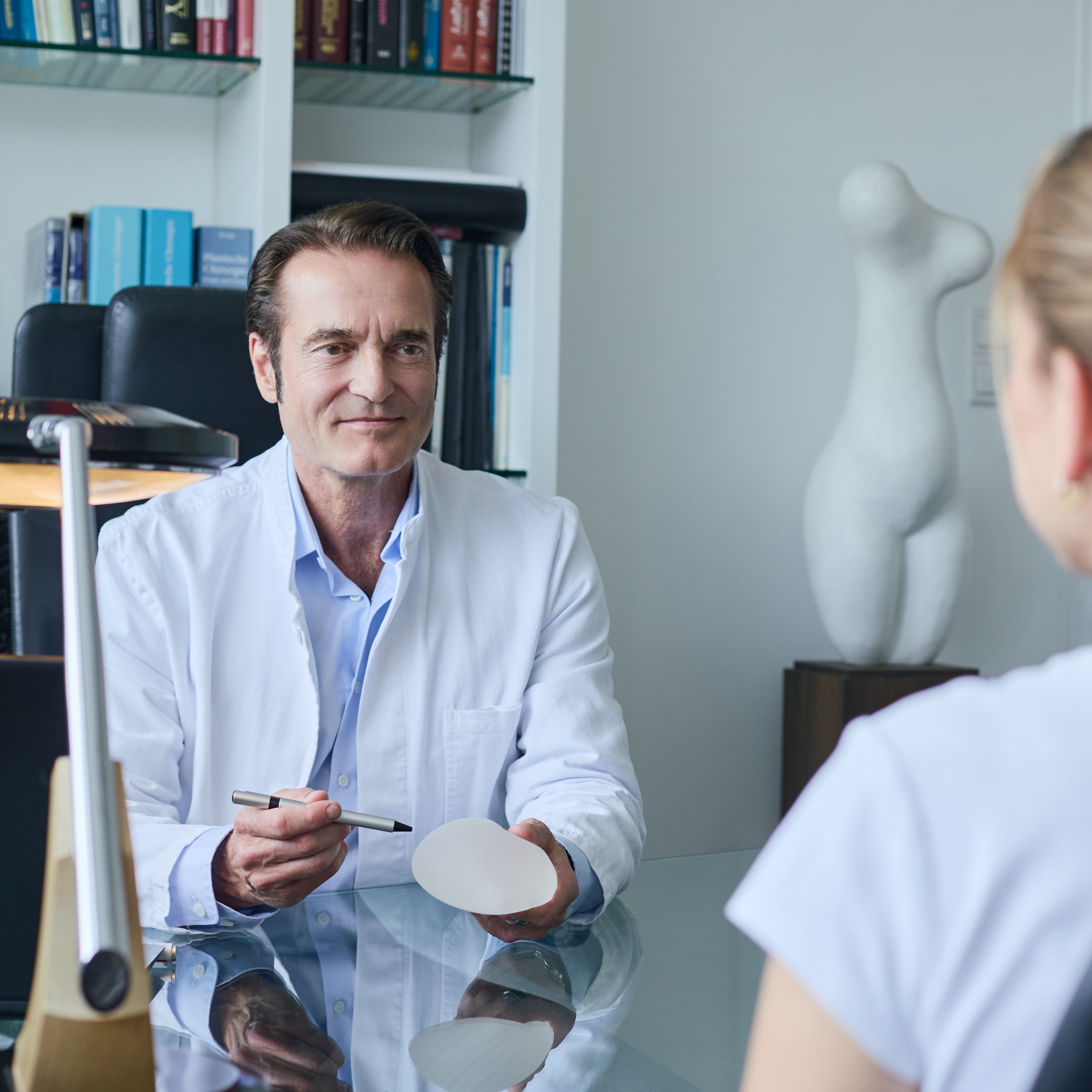Facharzt Dr. med. Christoph Reis bei einem Beratungsgespräch zu einer Brustvergrößerung mit einer Patientin