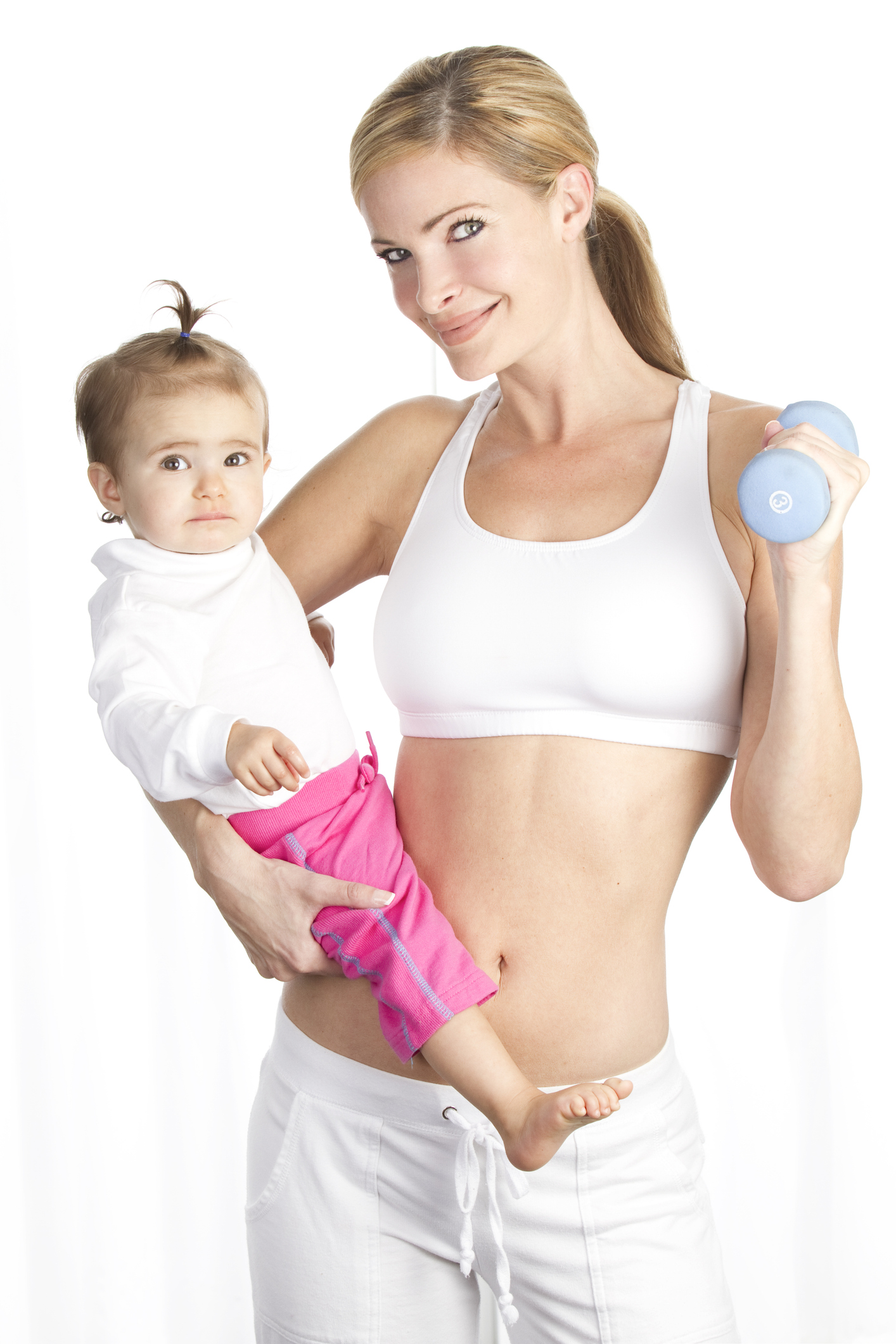 Junge Mutter in weißem Trainingsoutfit mit Baby auf dem Arm