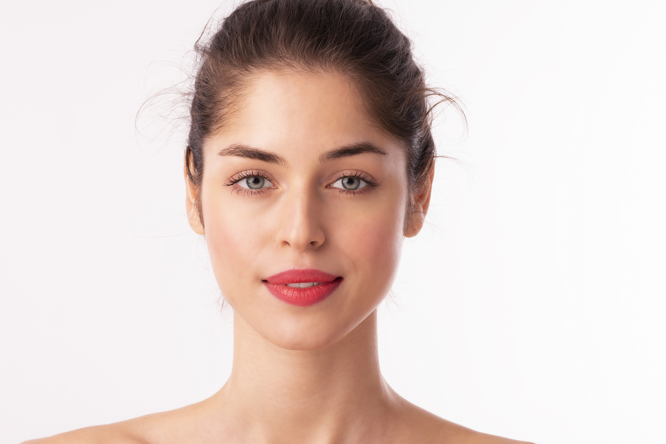 Gesicht einer jungen brünetten Frau mit grünen Augen und Lippenstift
