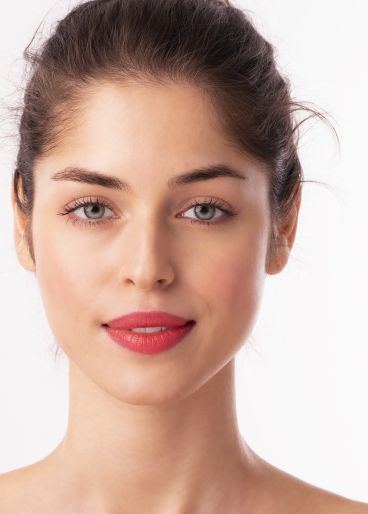 Gesicht einer jungen brünetten Frau mit grünen Augen und Lippenstift