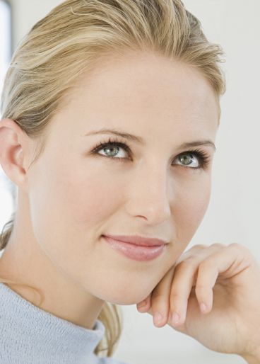 Junge blonde Frau schaut lächelnd nach oben