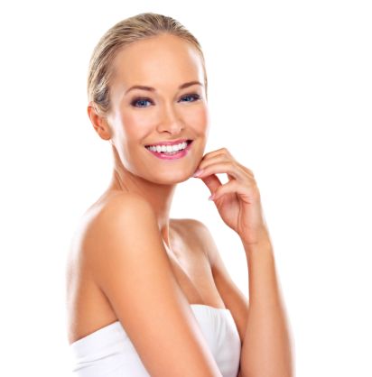 Junge Frau posiert mit Oberkörper im Seitenprofil und schaut lächelnd in Kamera