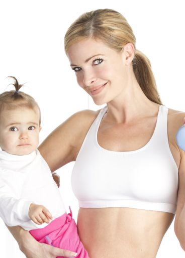 Junge Mutter in weißem Trainingsoutfit mit Baby auf dem Arm